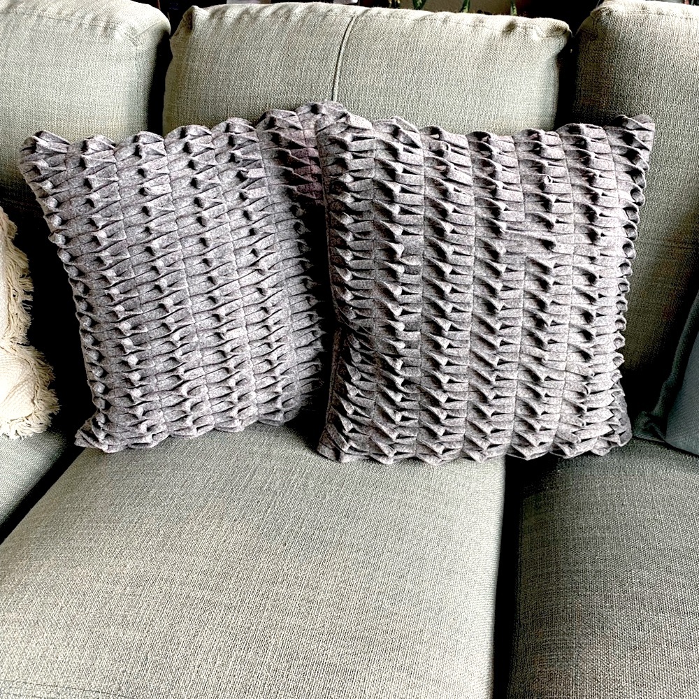Two grey felt decorative pillows.